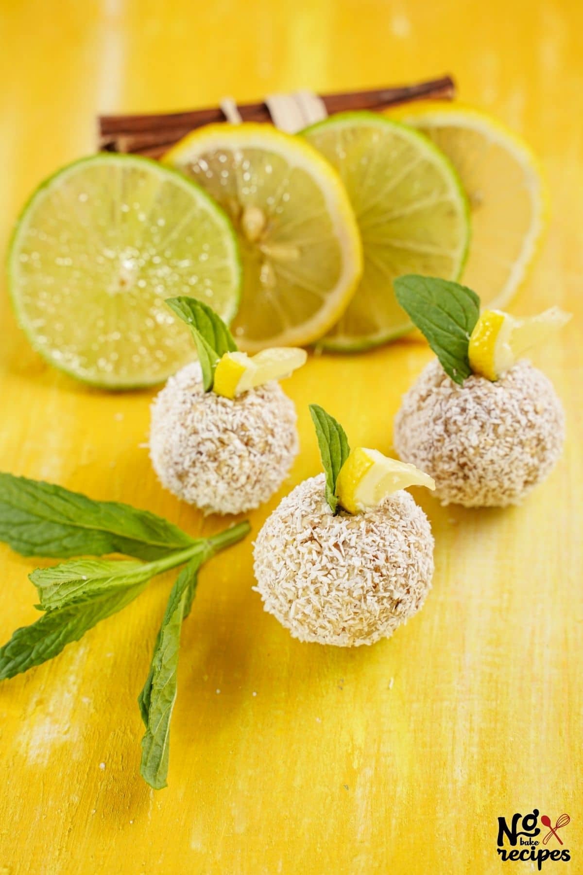 three lemon truffles on yellow table with mint and lemon slices