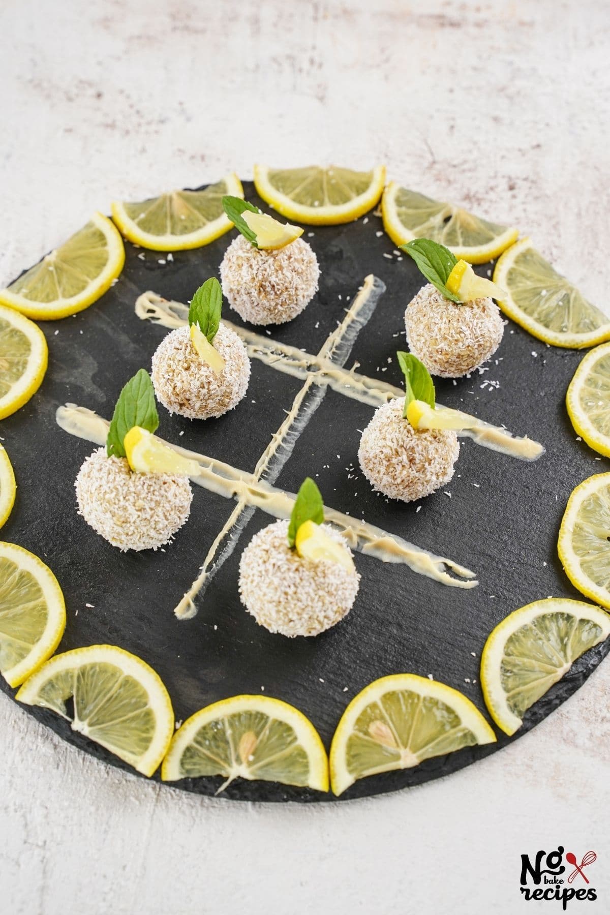 black platter with truffles in center and lemon slices around edge