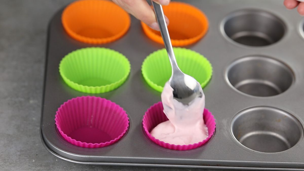 hand filling silicone muffin cups with yorgut