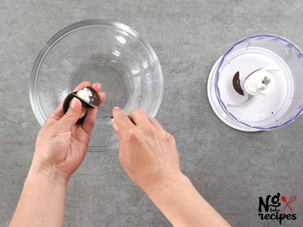 hands scooping cream out of oreo cookies