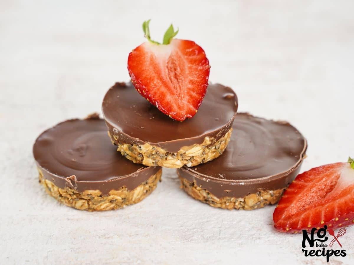 three chocolate oatmeal cups stacked in a pyramid with strawberry slice on top