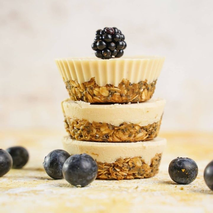 three white chocolate oatmeal cups stacked with blackberry on top