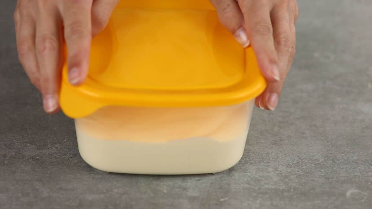 square bowl full of pudding with yellow lid
