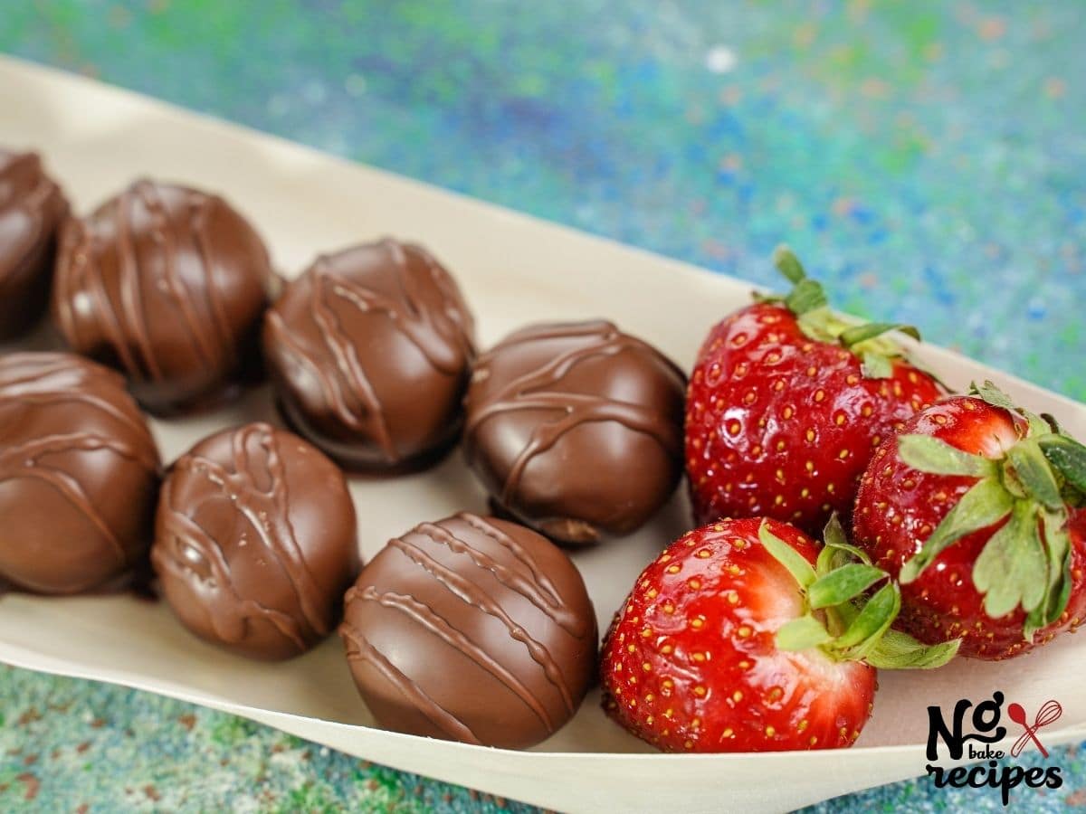 peanut butter cup truffles on parchment paper with strawberries