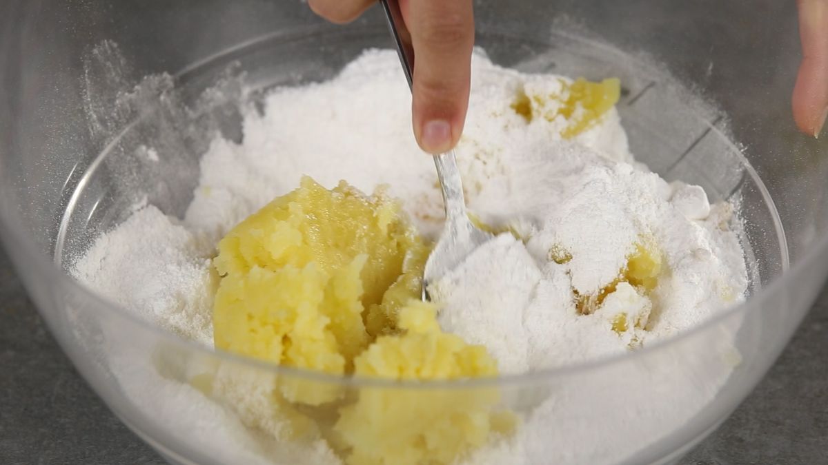 fork in bowl of potatoes and powdered sugar