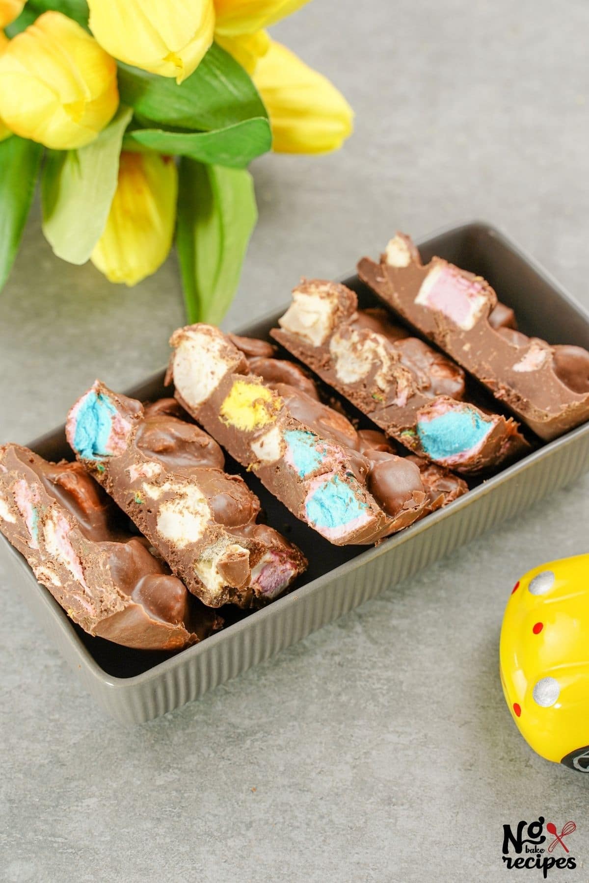 sliced rocky road bars in brown tray on gray table