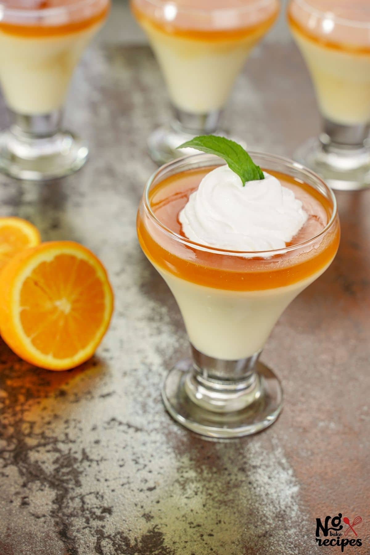 glasses of caramel pudding on brown table with orange slices