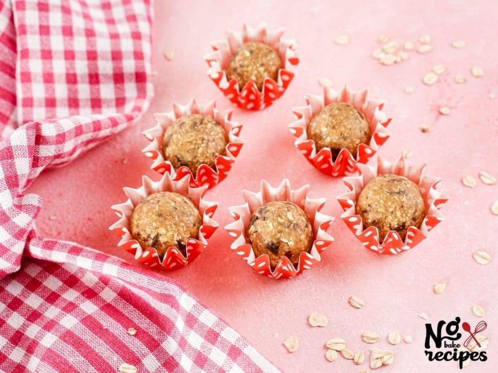 pink tablecloth with red and white checked napkin under red and white wrapped vegan energy balls