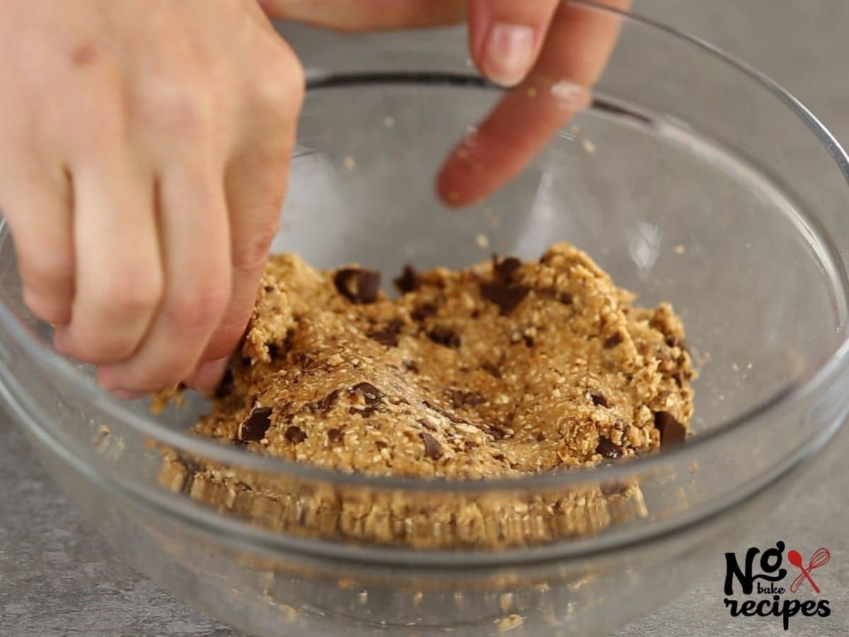 hand mixing protein ball dough in glass bowl