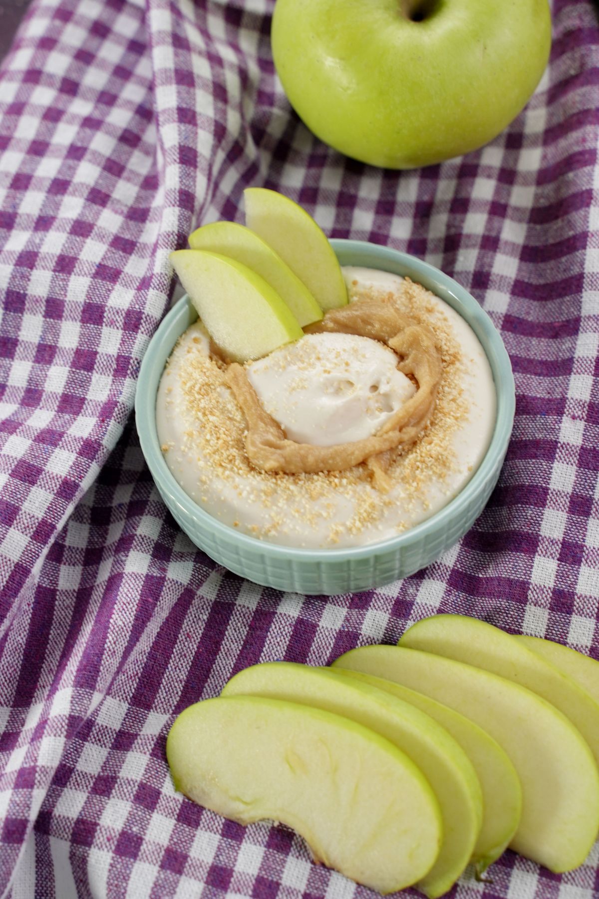 caramel apple cheesecake dip in a bowl with apple slices