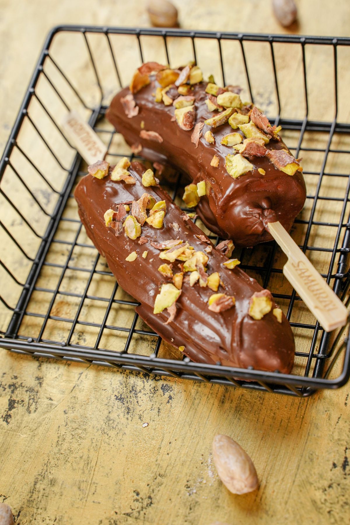 chocolate dipped banana pops with pistachio topping