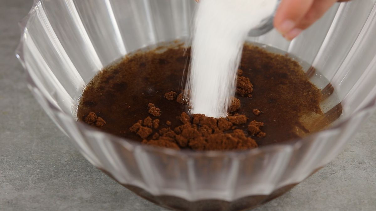 Add hot water, coffee powder and sugar in a bowl and mix well.