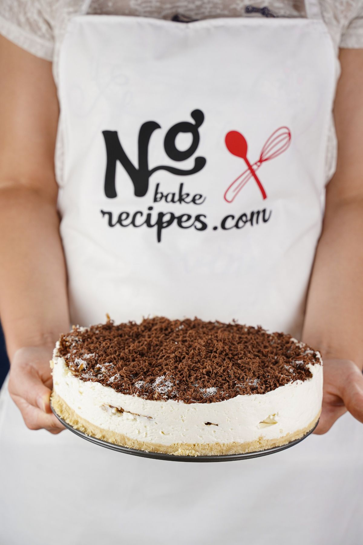 woman in no bake recipes apron holding pie with chocolate on top