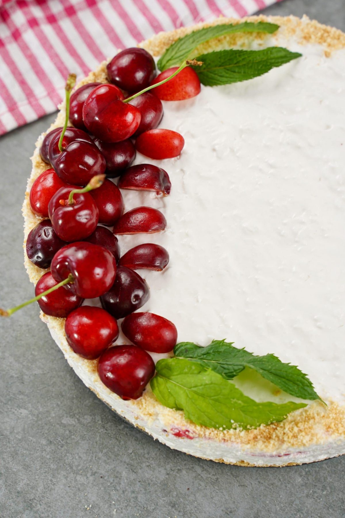 top of cheesecake with mint and fresh cherries
