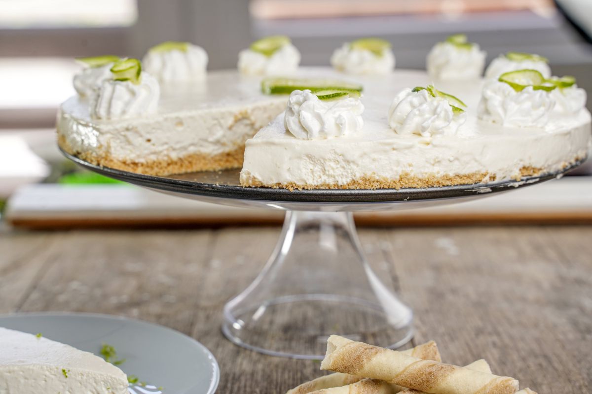 cake stand holding lime tart with dollops of whipped cream on top