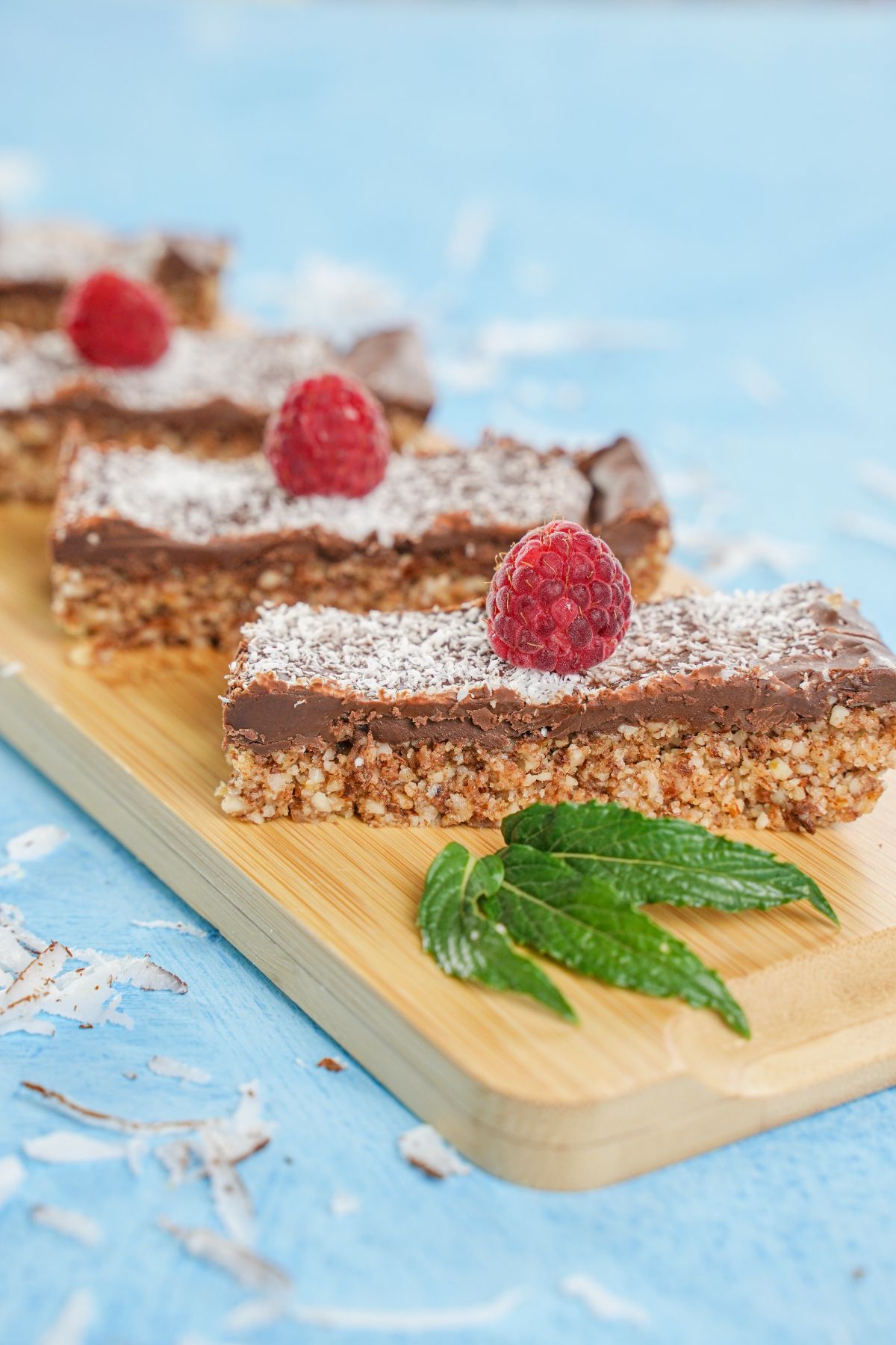 No-Bake Toasted Coconut and Almond Granola Bars decorated with fresh raspberry and mint leaves 