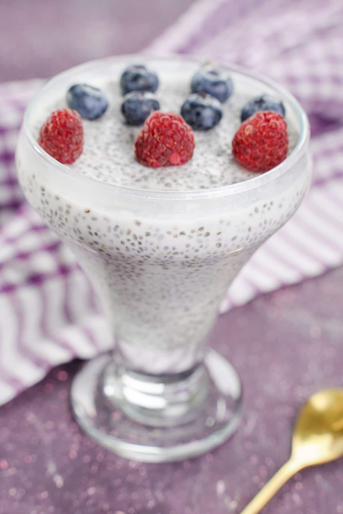 no-bake chai pudding topped with blueberries and raspberries in a glass