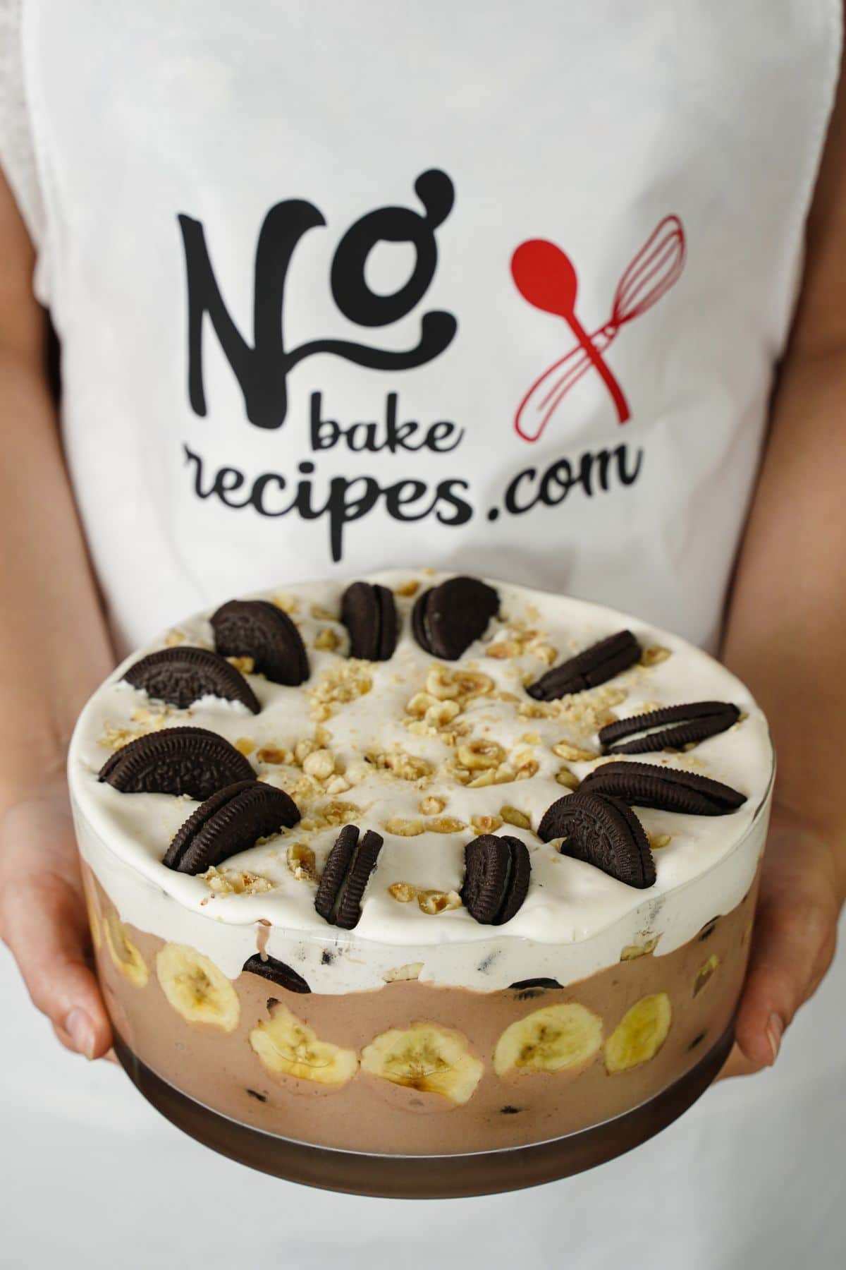 woman holding trifle bowl of oreo nutella banana pudding