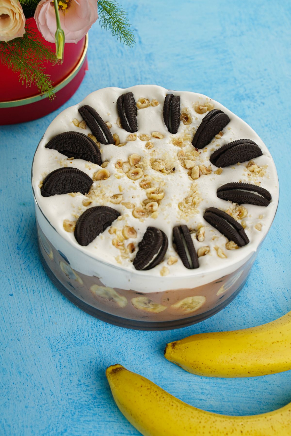 layered Nutella oreo banana pudding in glass bowl on blue table