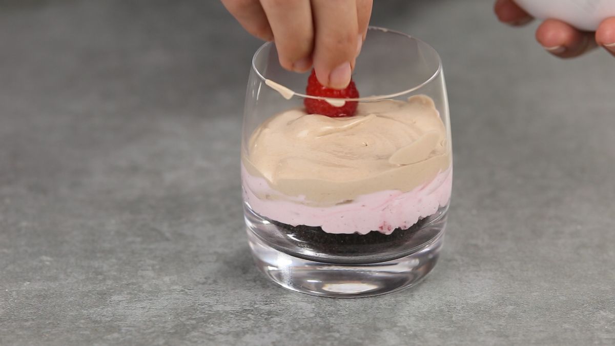 hand adding raspberry on top of nutella cream