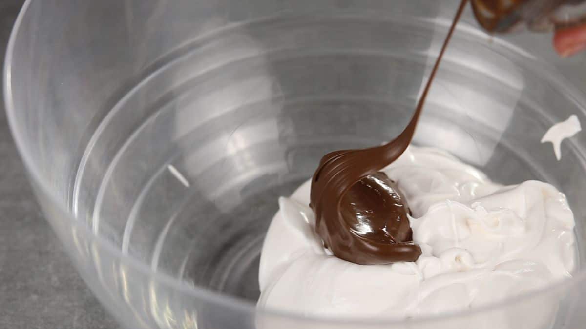 spoon of nutella over whipped cream
