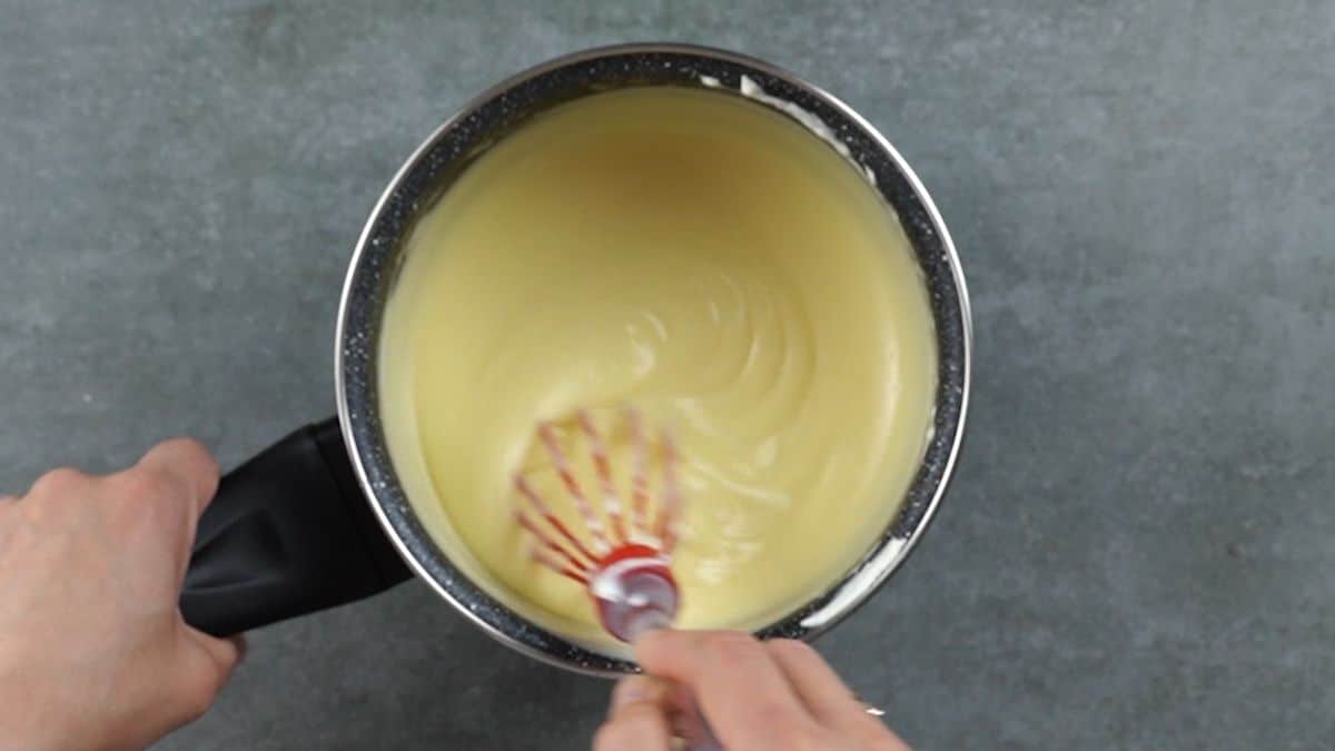hand whisking pudding in saucepan
