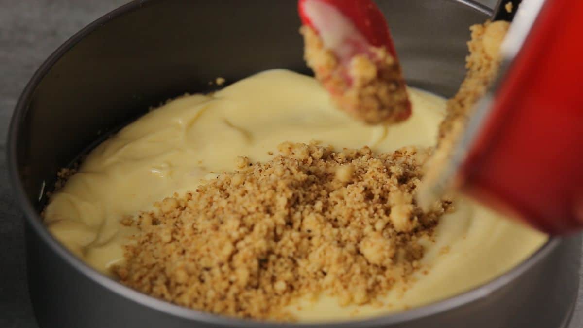 spreading crumbs over top of pudding in pan