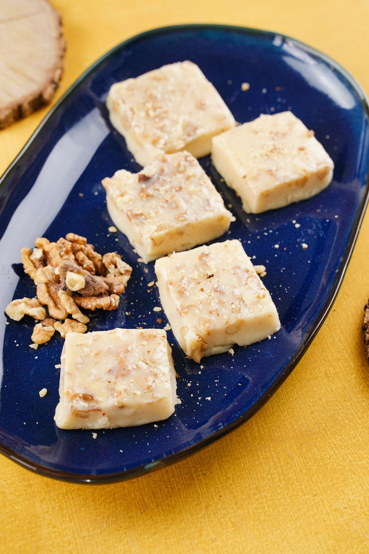 Butter Walnut Fudge served in a blue dish with some fresh walnuts