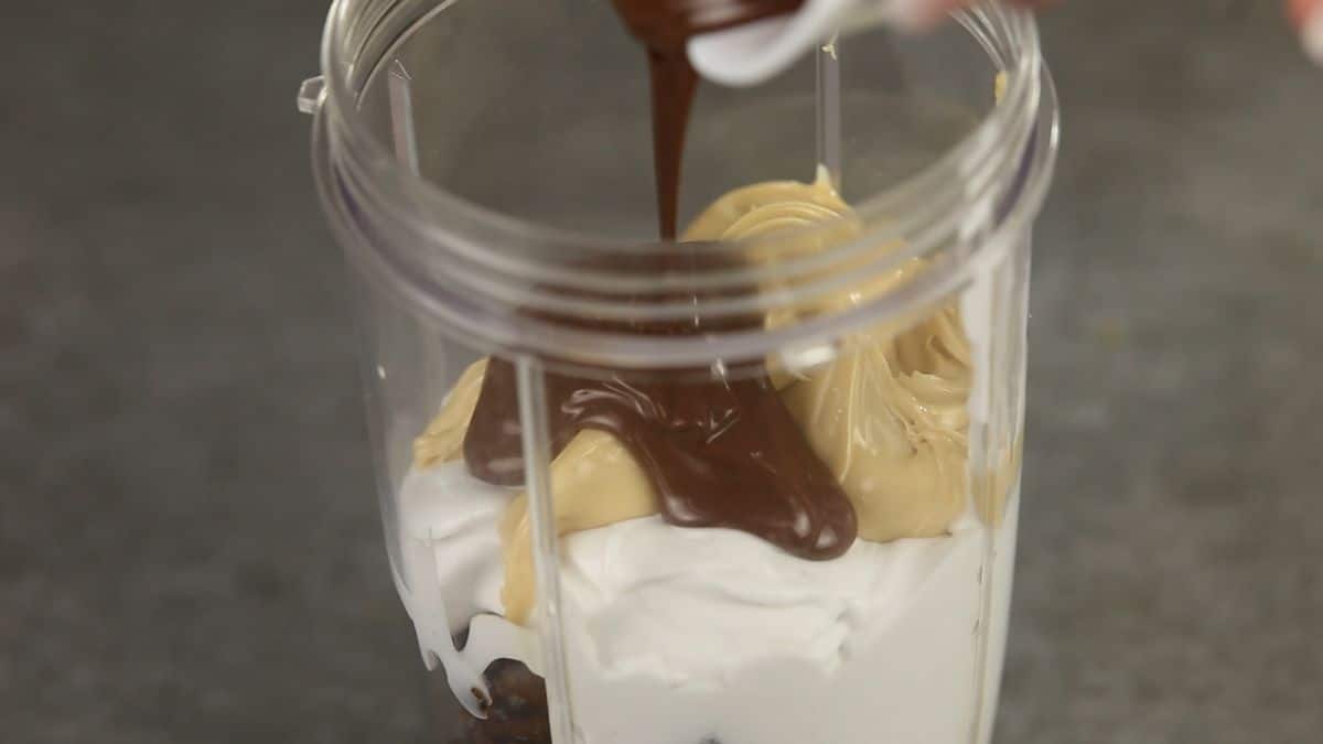 Dates, coconut milk, protein cream and melted chocolate are blended in a food processor