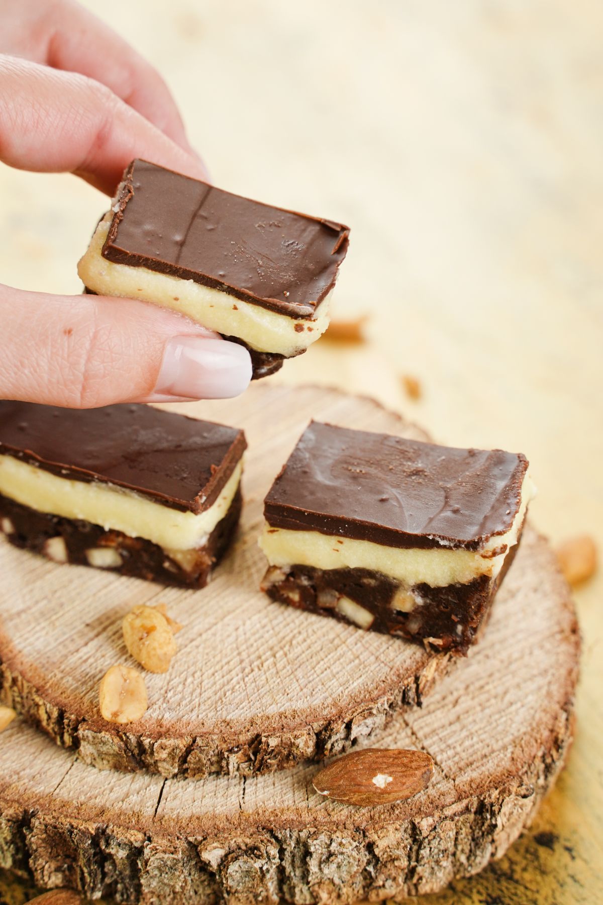 A piece of Copycat Nanaimo Bars in hand