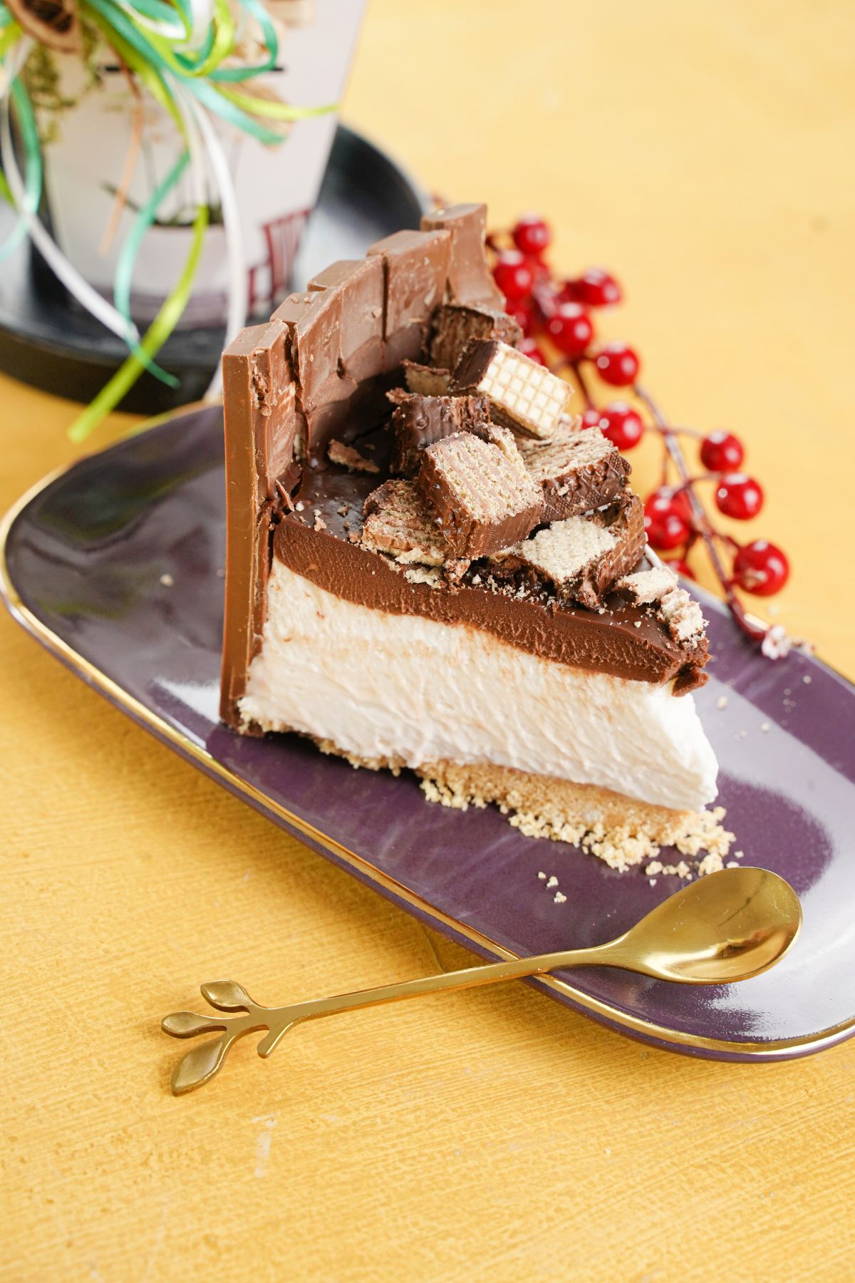 No-Bake Kit Kat Cheesecake served with golden spoon and cherries on the sides