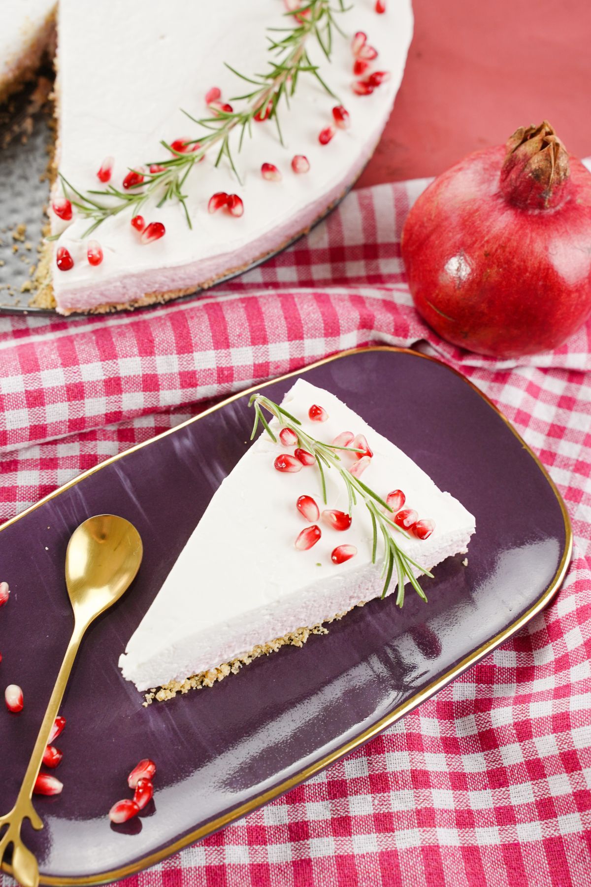 A piece of No-Bake Pomegranate Cheesecake with golden spoon 