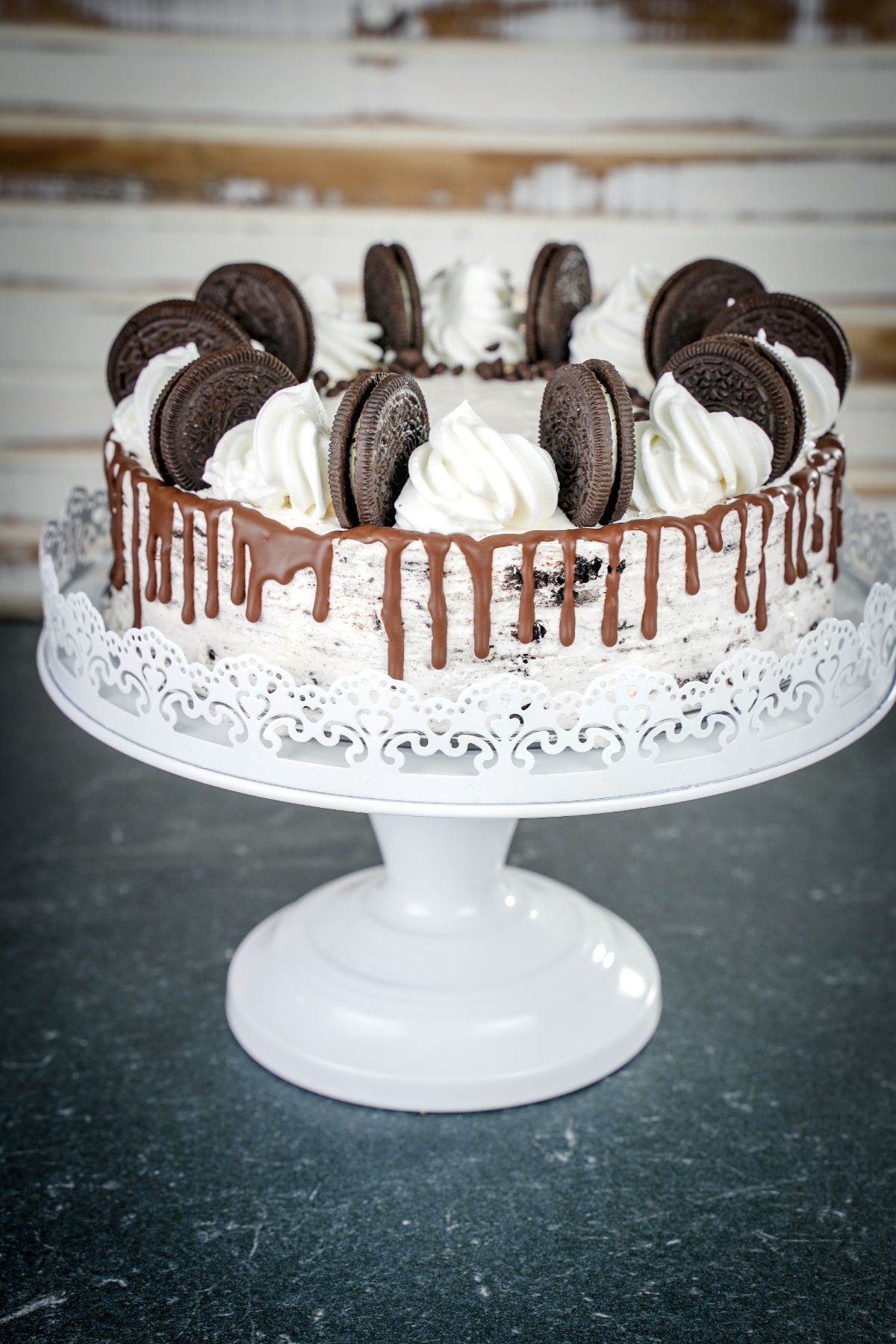 oreo icebox cake with chocolate drizzle on a cake plate