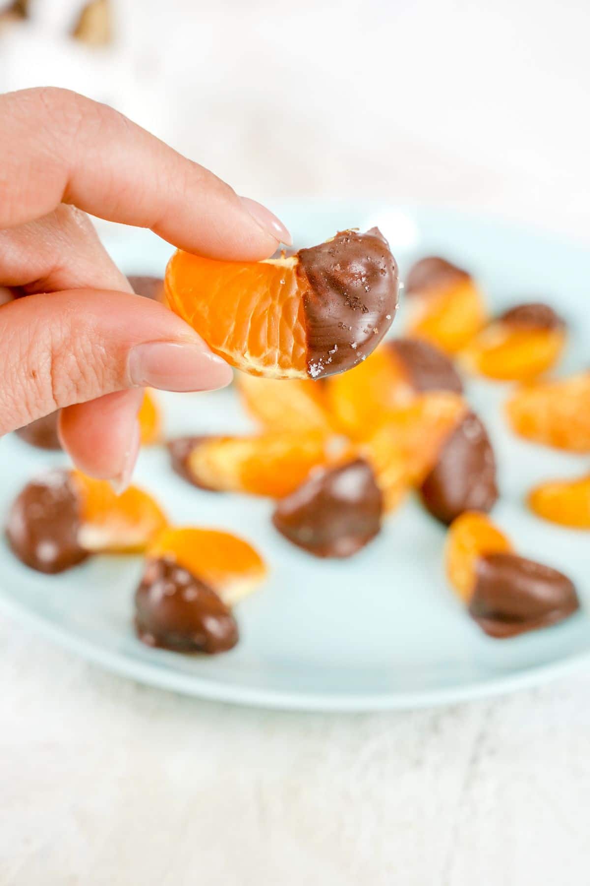 A piece of Chocolate Covered Oranges in fingers