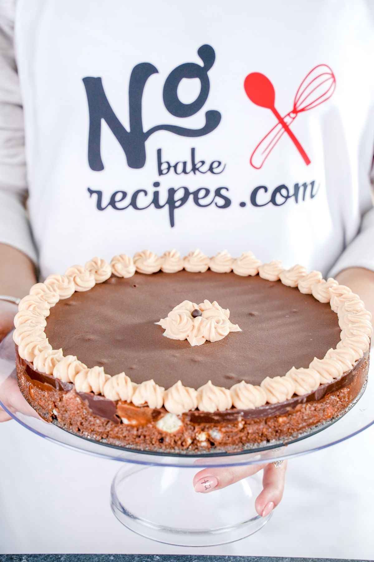 No-Bake Cookie Cake on a glass stand in hand