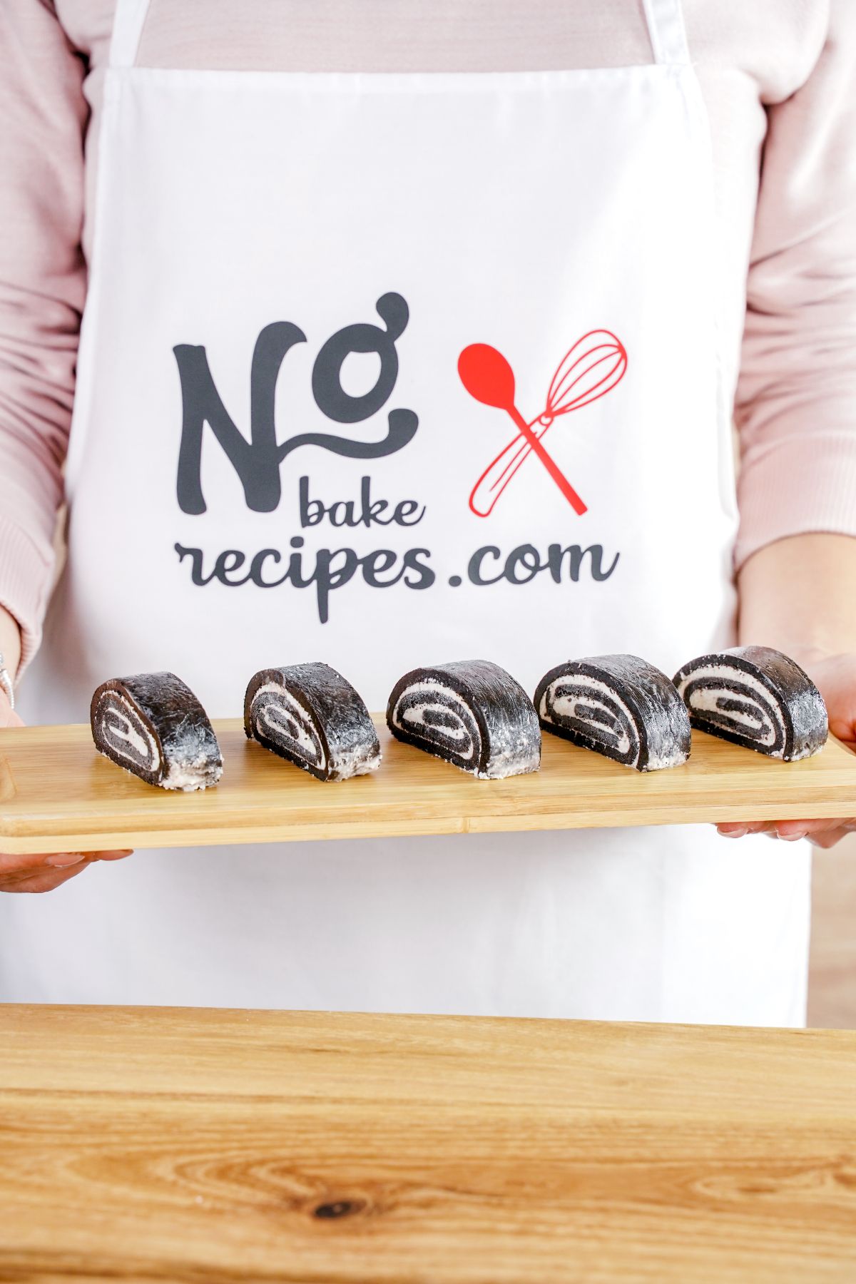 No-Bake Oreo Sushi served on a wooden plater in hand
