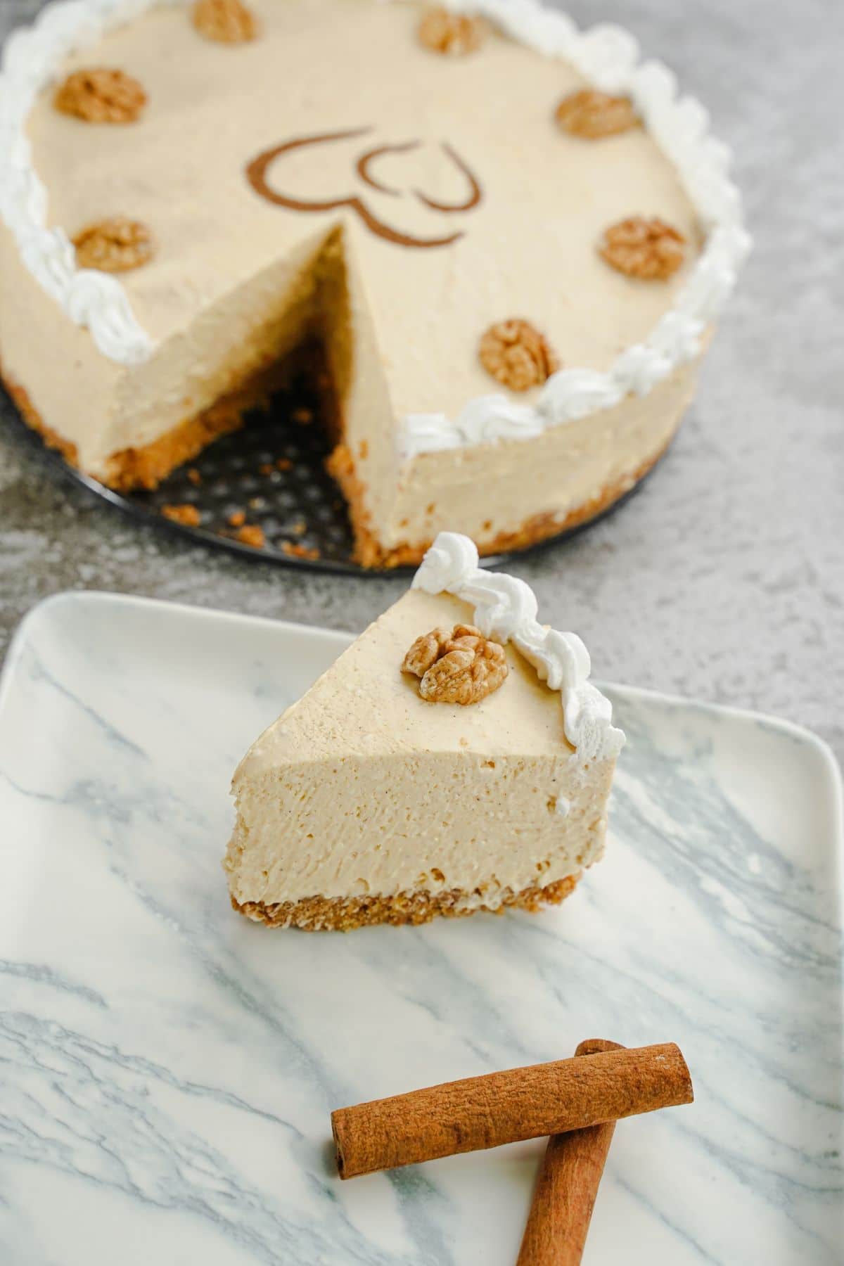 A piece of No Bake Pumpkin Cheesecake cut out from the whole cheesecake