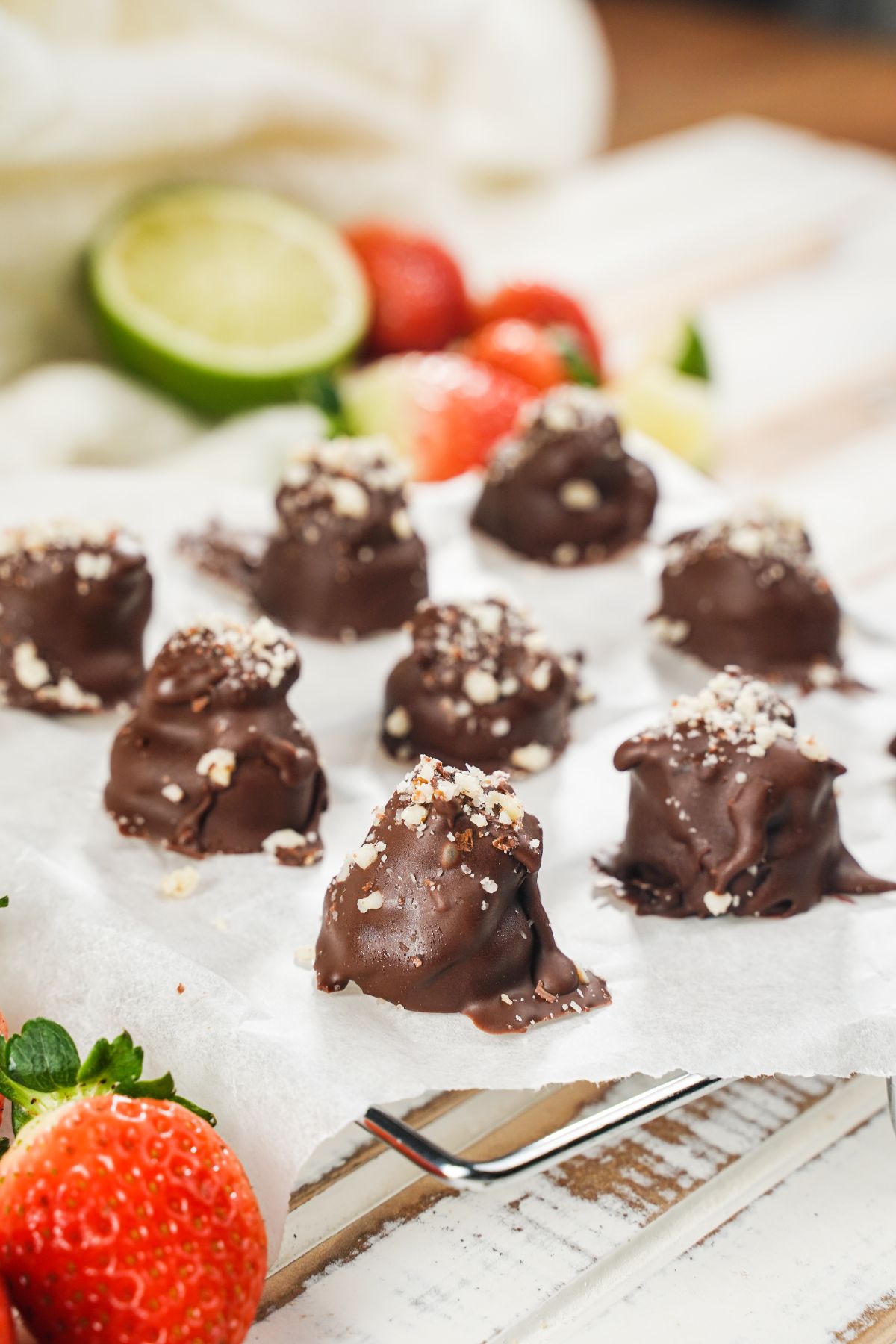 No-Bake Snickers Bites served on a white paper with some fresh fruits