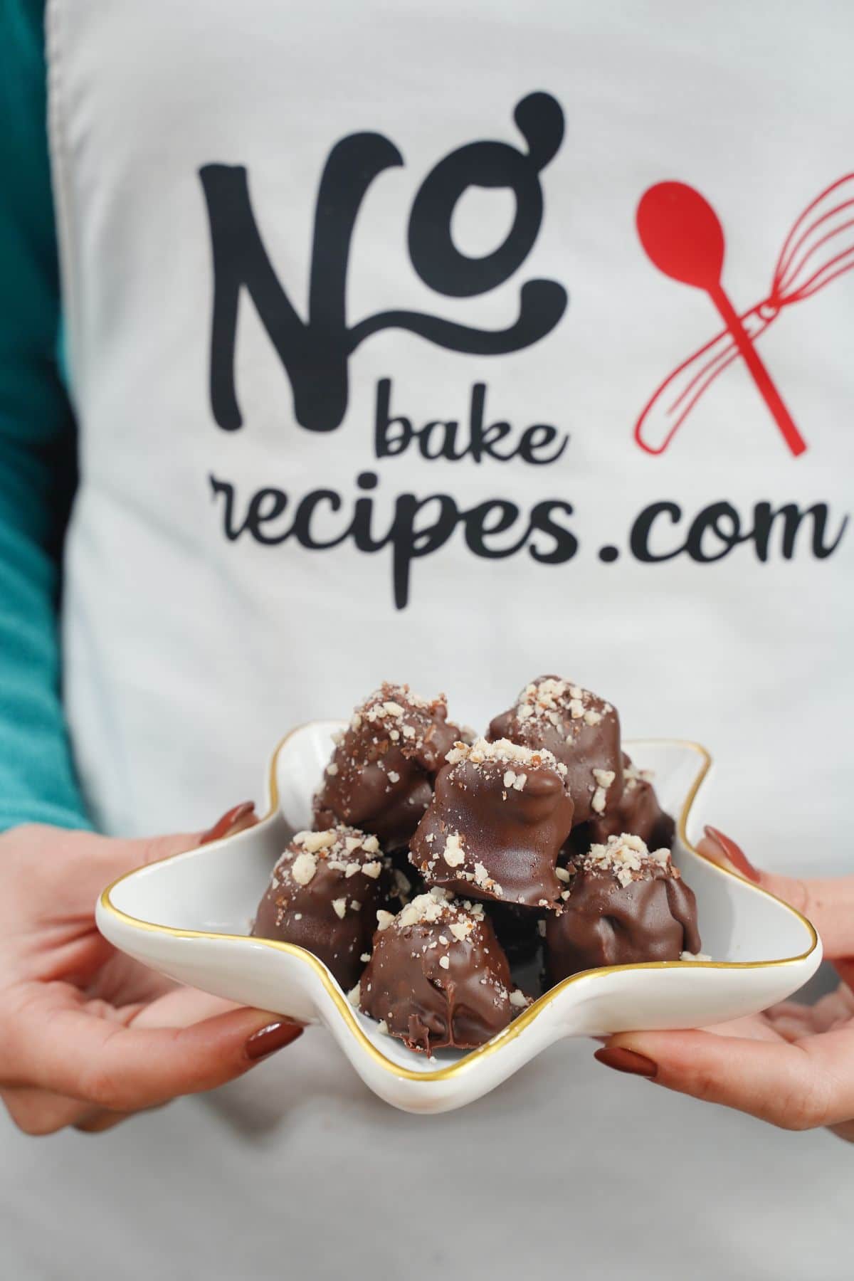 No-Bake Snickers Bites served on a white plate in hand