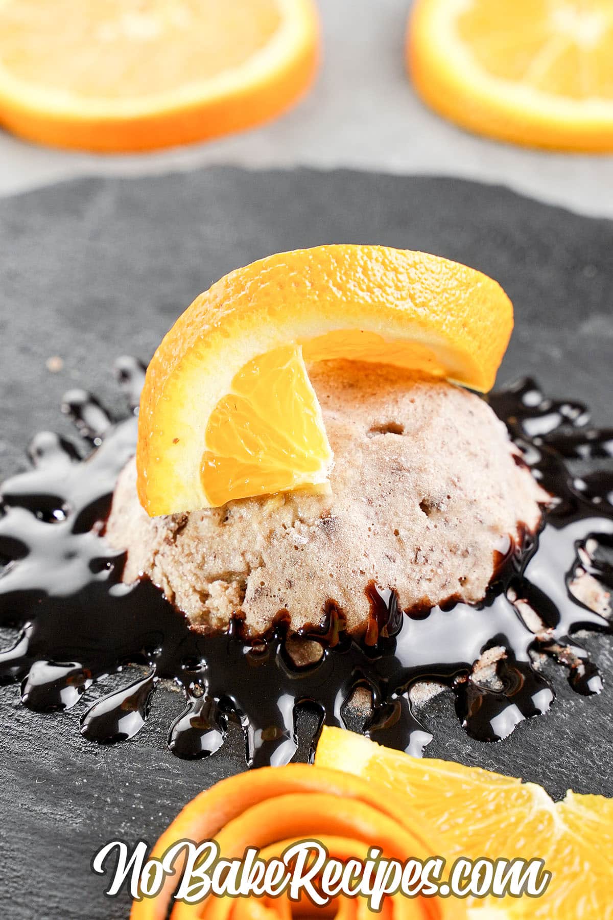 scoop of banana chocolate ice cream on a plate with chocolate and orange slices