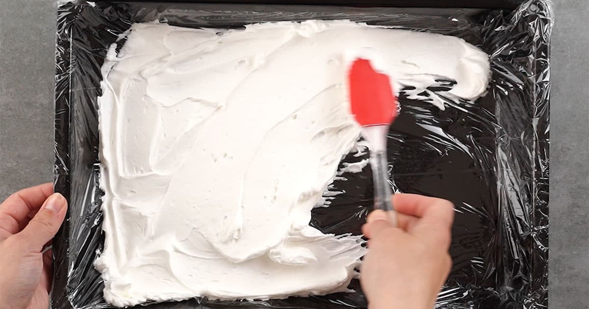 Strawberry Icebox Cake being layere din a cake pan