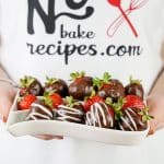 person holding a plateful of boozy chocolate covered strawberries