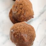 row of chocolate rum truffles on a marble surface