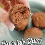 rum ball bitten in half held in between two fingers with text which reads chocolate rum truffles