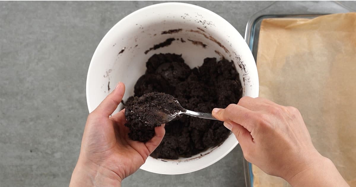 making oreo truffles by scooping the dough into a hand and rolling them into a ball