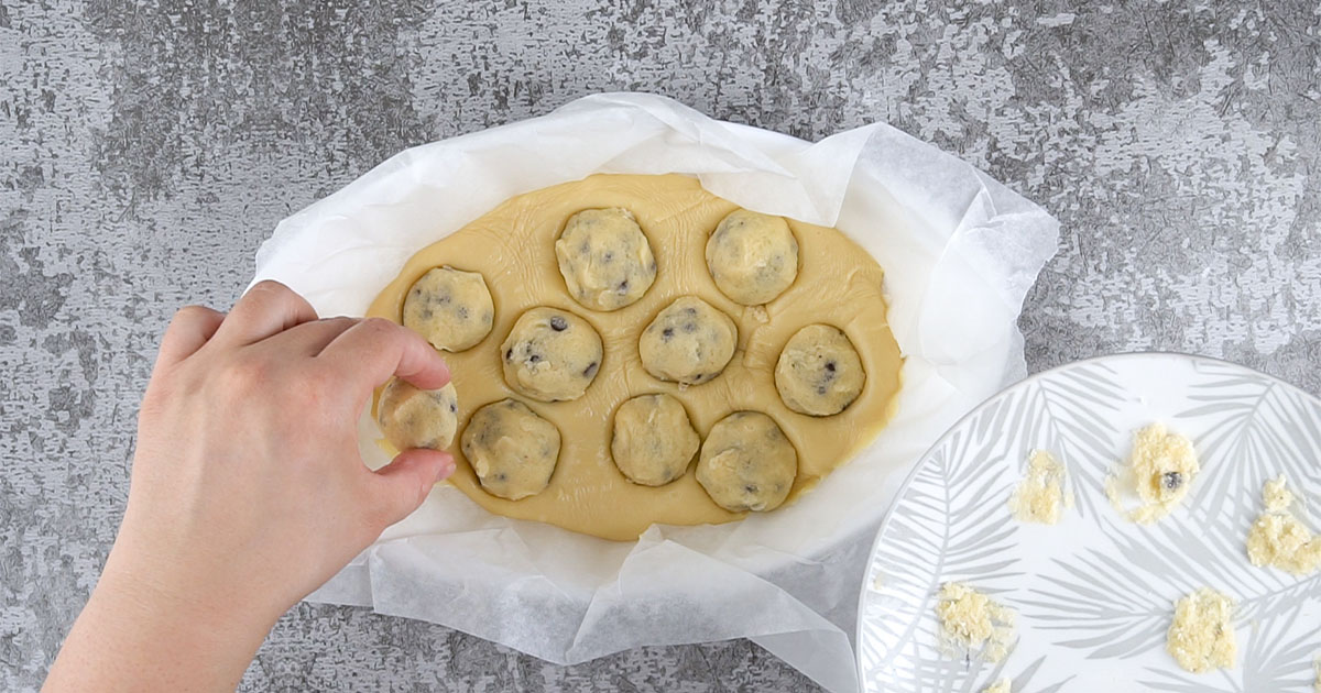 cookie dough balls being placed in fudge mixture to make Cookie Dough Fudge