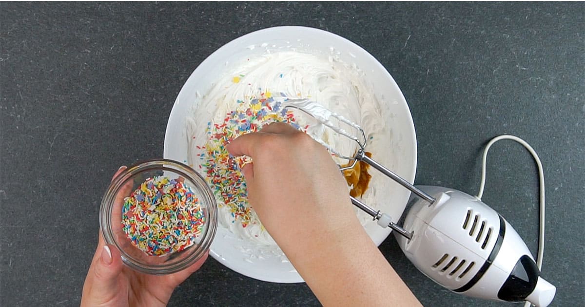 adding sprinkles to cheesecake filling to make no-bake Funfetti Cheesecake