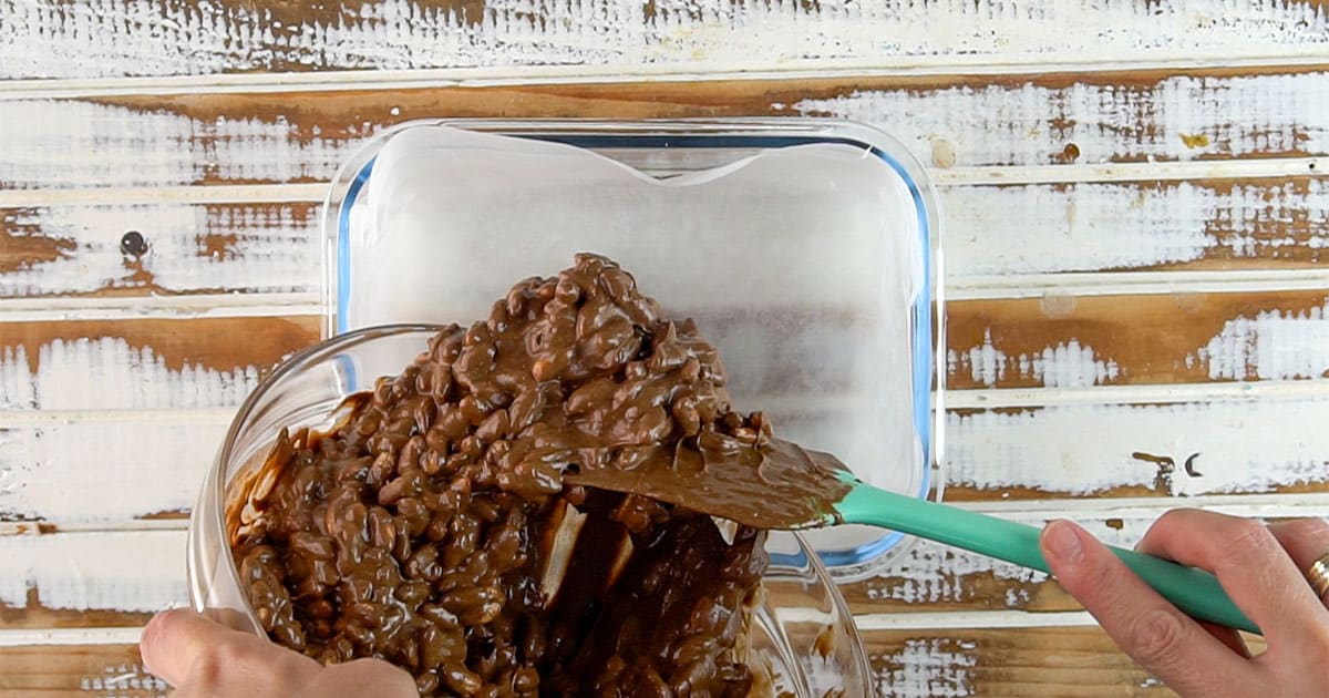 peanut butter crunch bars being poured into a cake pan