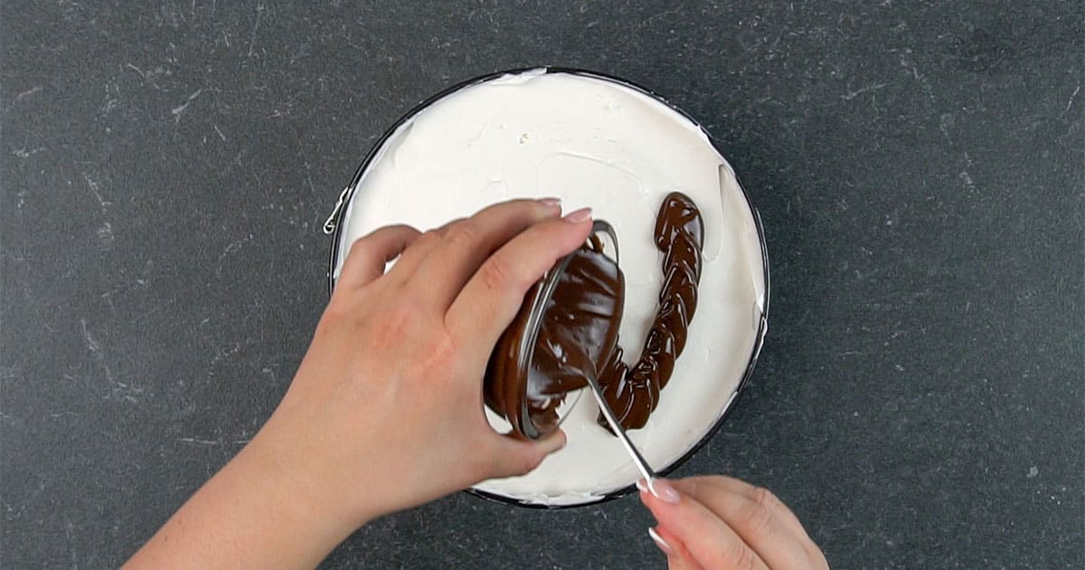 adding layer of chocolate to the top of cheesecake to make a no-bake smores cheesecake