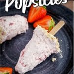 cheesecake and strawberry popsicles laying on a plate with text which reads strawberry cheesecake popsicles